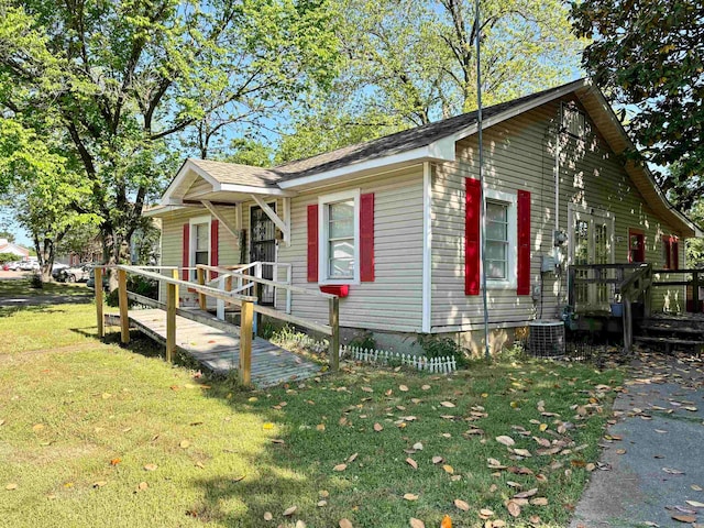 view of front of property with central AC, a deck, and a front lawn