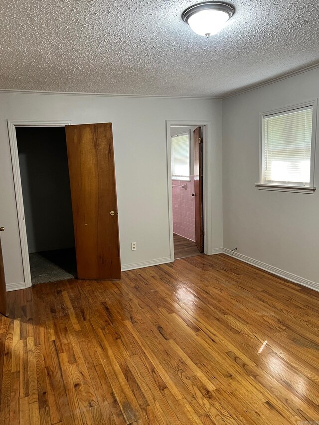 spare room featuring wood-type flooring and a textured ceiling