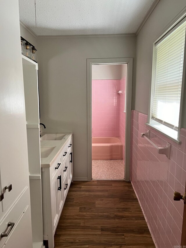 bathroom featuring tile walls, plenty of natural light, vanity, and hardwood / wood-style floors