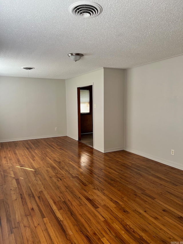 unfurnished room featuring dark hardwood / wood-style flooring and a textured ceiling