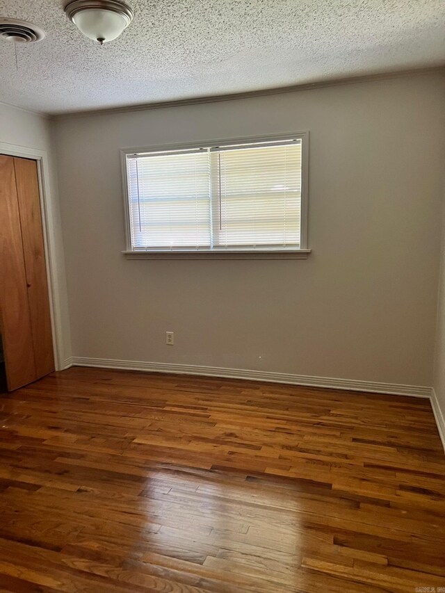 interior space with hardwood / wood-style floors, a closet, and a textured ceiling