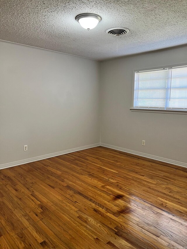 spare room with dark hardwood / wood-style flooring and a textured ceiling