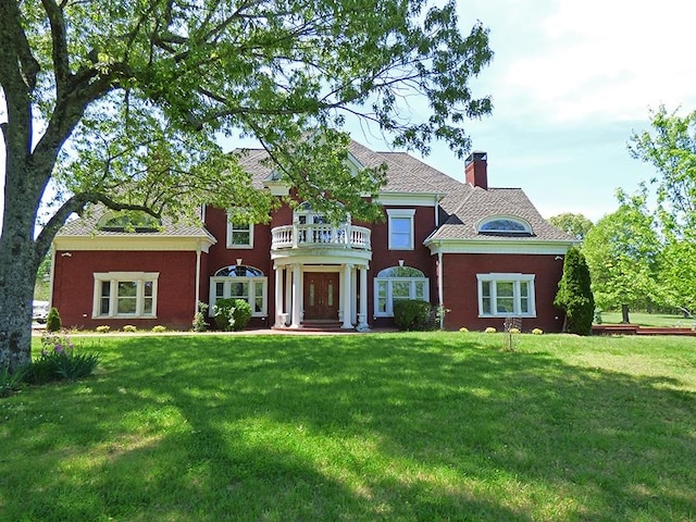 view of front of house with a front lawn and a balcony