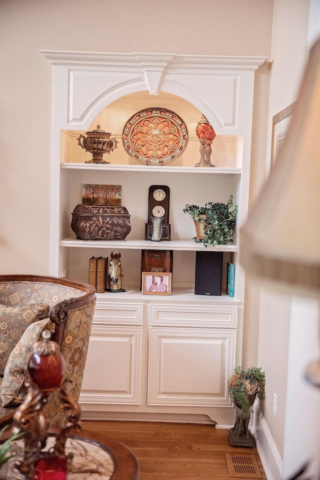 interior details featuring built in shelves and hardwood / wood-style flooring