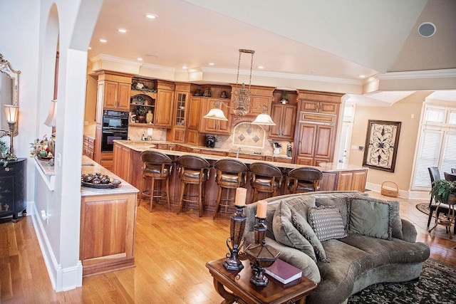 living room featuring light hardwood / wood-style floors, ornamental molding, and lofted ceiling