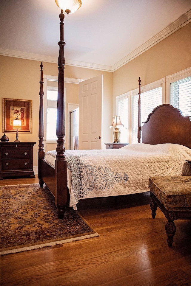 bedroom with crown molding and dark hardwood / wood-style flooring