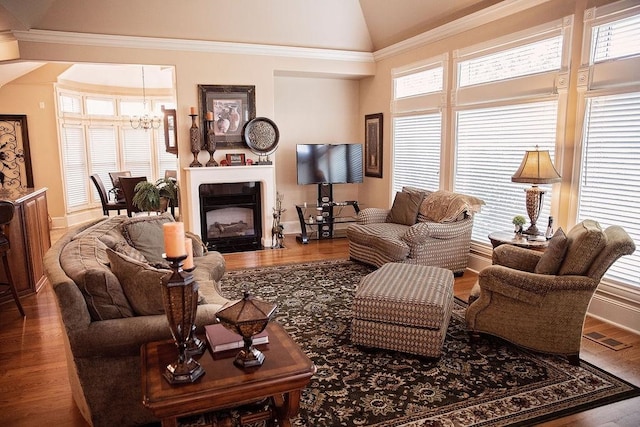 living room featuring a notable chandelier, ornamental molding, high vaulted ceiling, and hardwood / wood-style floors