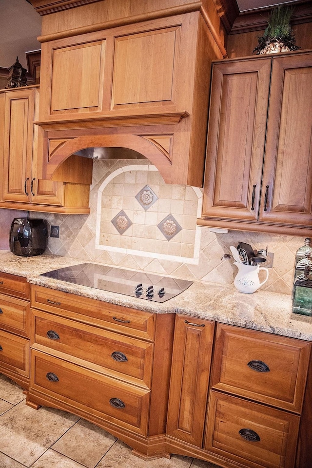 kitchen with light stone countertops, light tile flooring, and tasteful backsplash