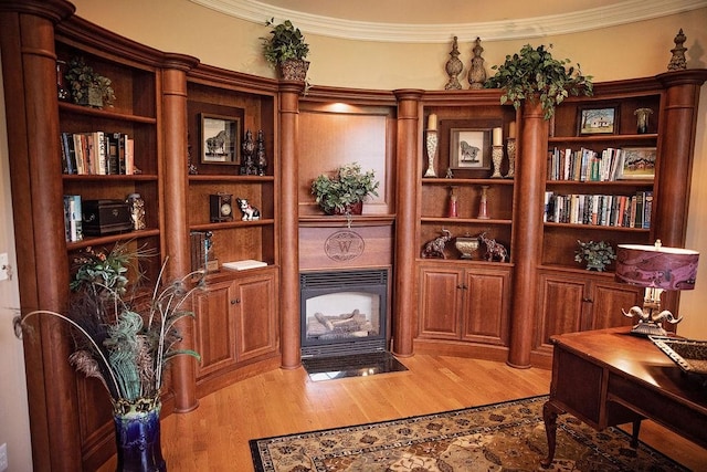 office area with light hardwood / wood-style floors and crown molding