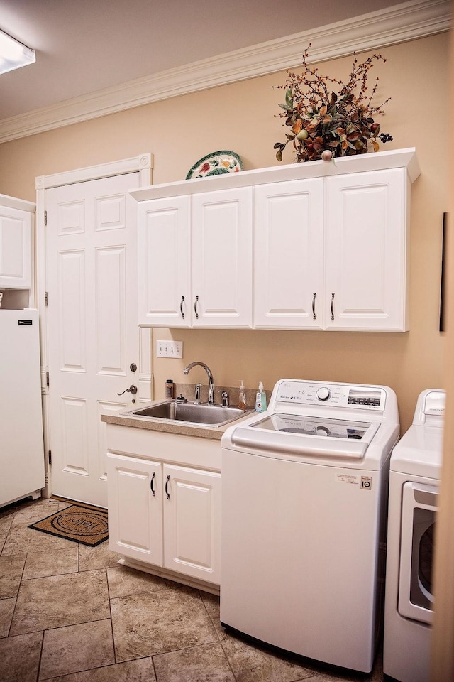 clothes washing area featuring cabinets, separate washer and dryer, ornamental molding, sink, and light tile floors