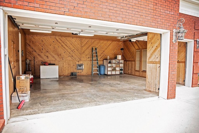 garage featuring wooden walls and refrigerator