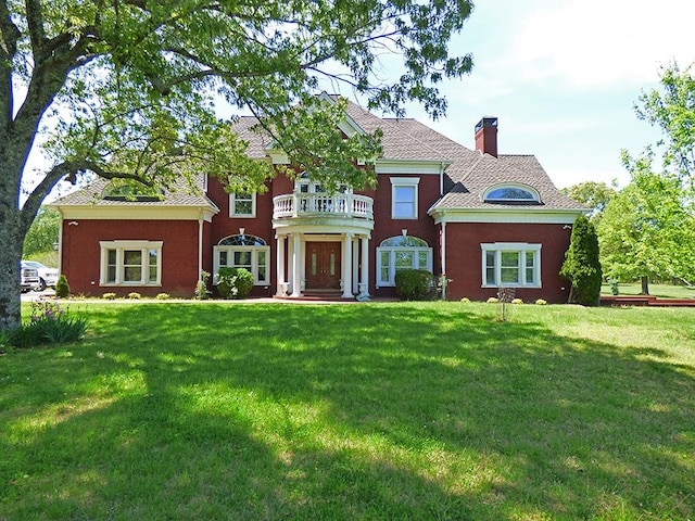 view of front of property with a front lawn and a balcony