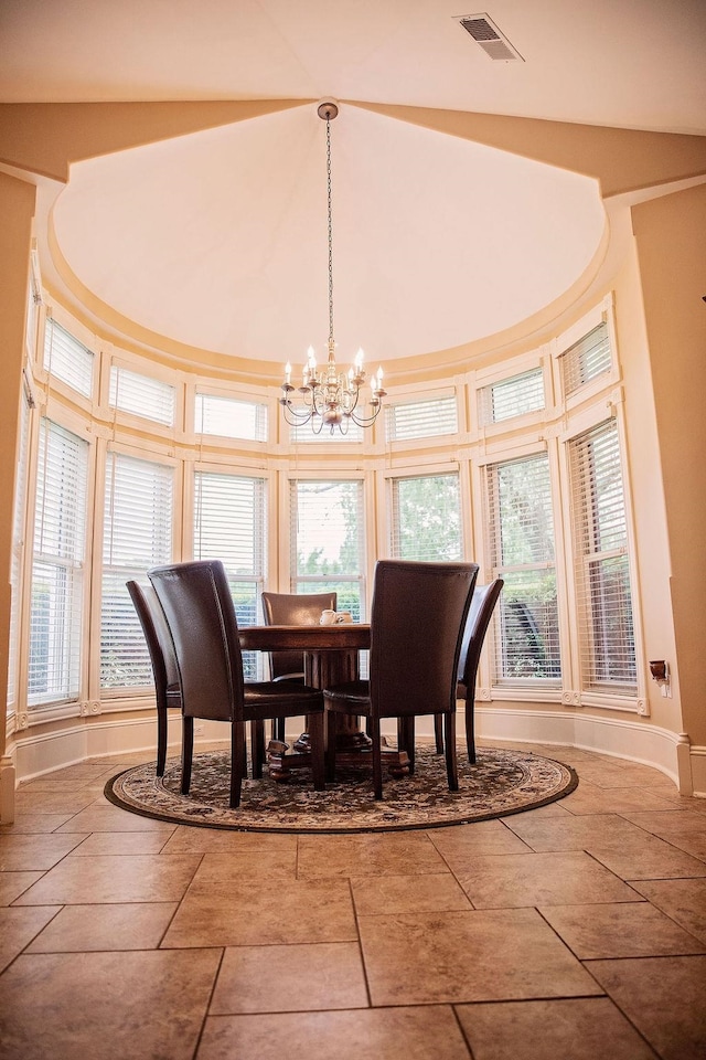 dining area featuring tile flooring, a towering ceiling, and an inviting chandelier