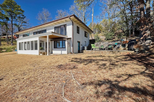 rear view of house featuring a balcony and a sunroom