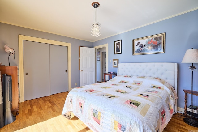 bedroom featuring hardwood / wood-style floors, a closet, and crown molding