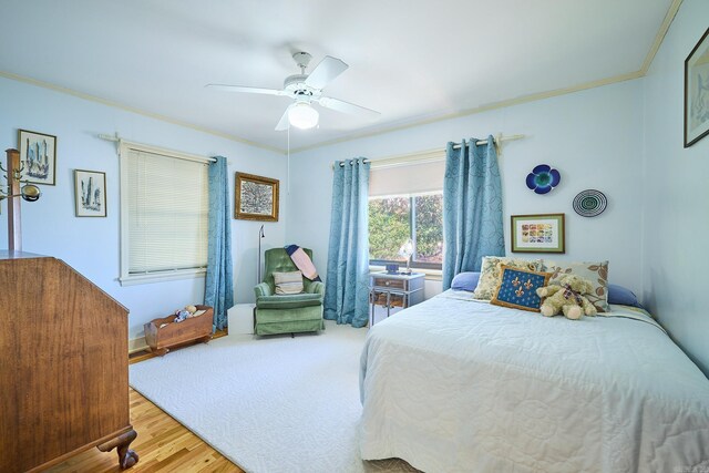 bedroom with ornamental molding, ceiling fan, and hardwood / wood-style flooring