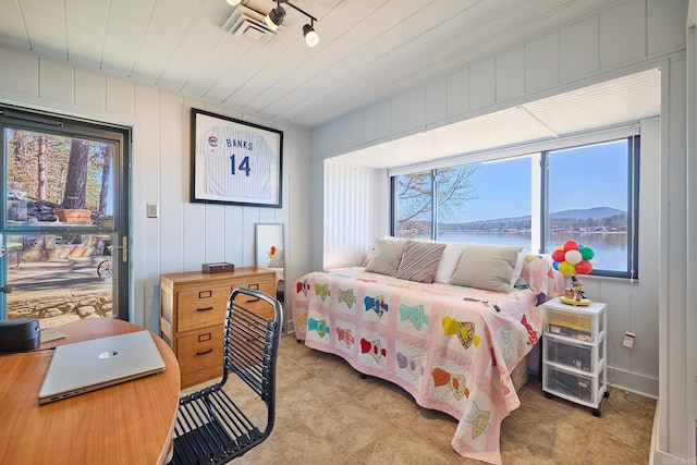 tiled bedroom featuring multiple windows and a water view