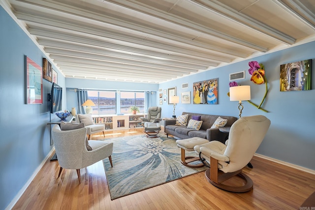 living room with beamed ceiling and hardwood / wood-style floors