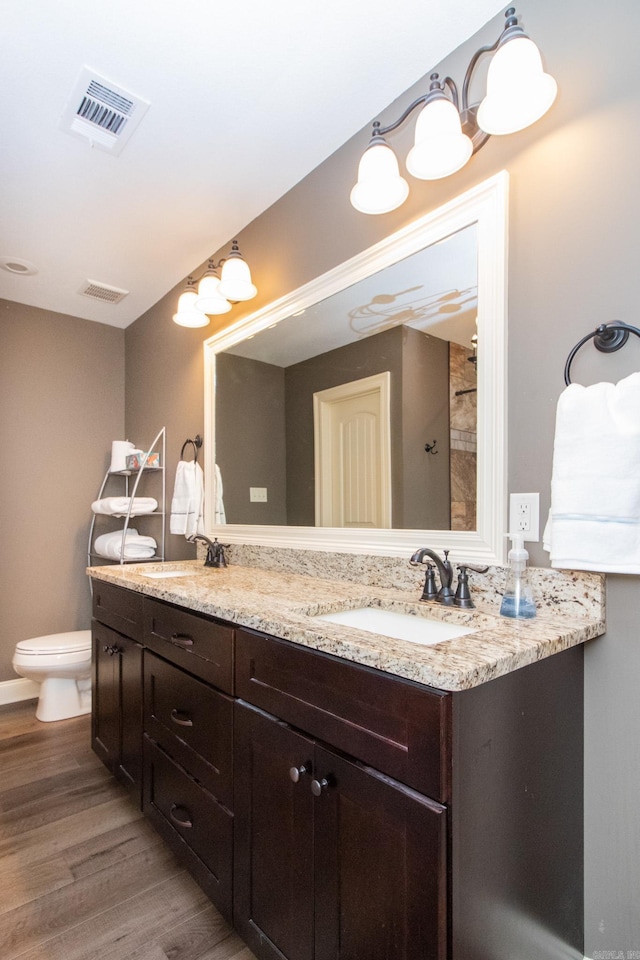 bathroom with vanity, toilet, hardwood / wood-style flooring, and walk in shower