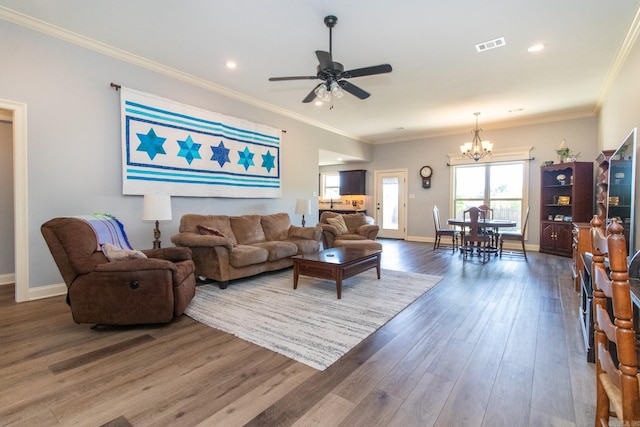 living room with dark wood-type flooring, crown molding, and ceiling fan with notable chandelier