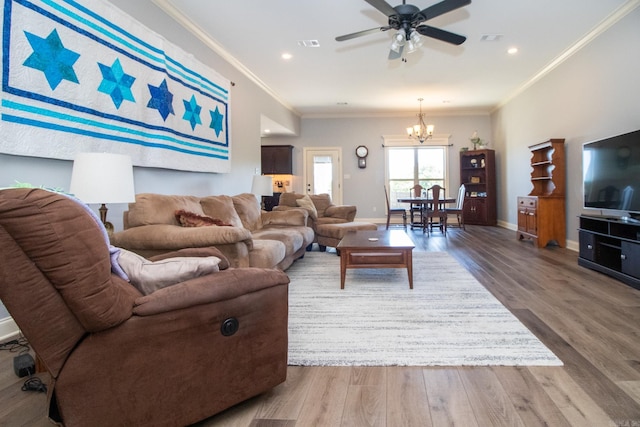 living room with ornamental molding, hardwood / wood-style flooring, and ceiling fan with notable chandelier