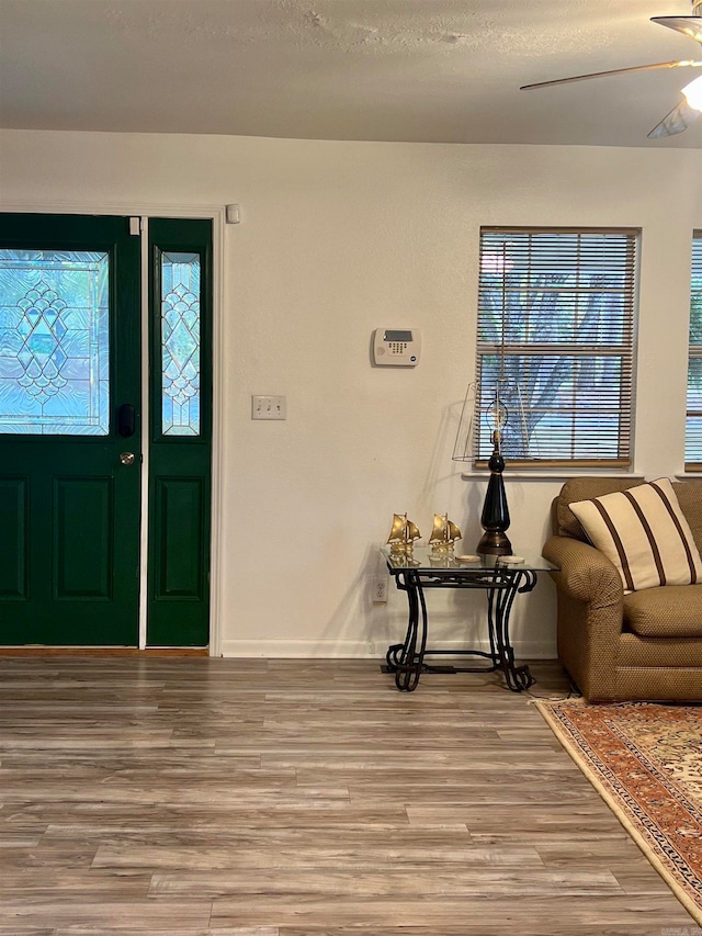 entryway with a textured ceiling, ceiling fan, and light hardwood / wood-style floors