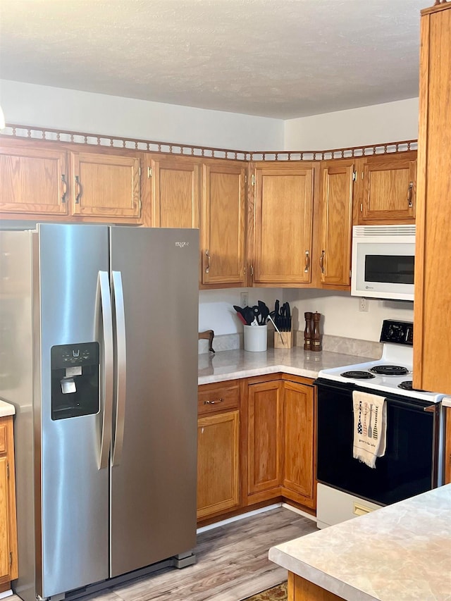 kitchen featuring light hardwood / wood-style flooring and white appliances