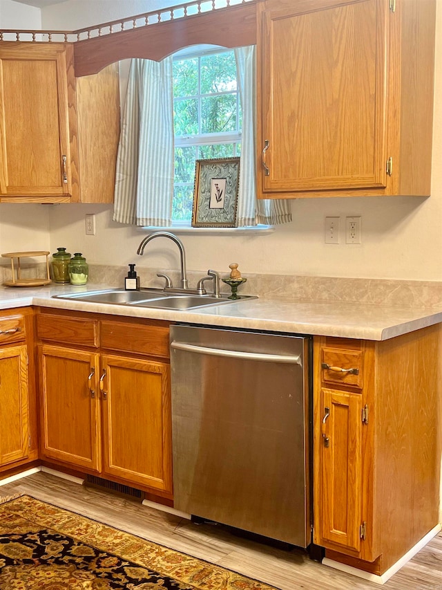 kitchen with sink, light hardwood / wood-style floors, and stainless steel dishwasher