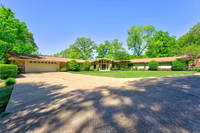 single story home with a garage and a front lawn