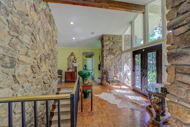 foyer featuring french doors, a healthy amount of sunlight, beamed ceiling, and parquet flooring