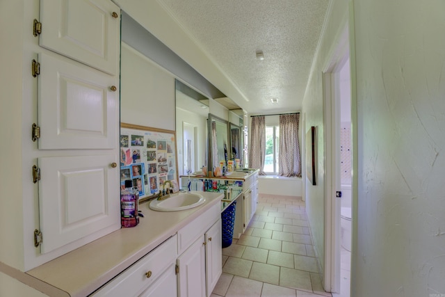 bathroom featuring toilet, tile flooring, a textured ceiling, and large vanity