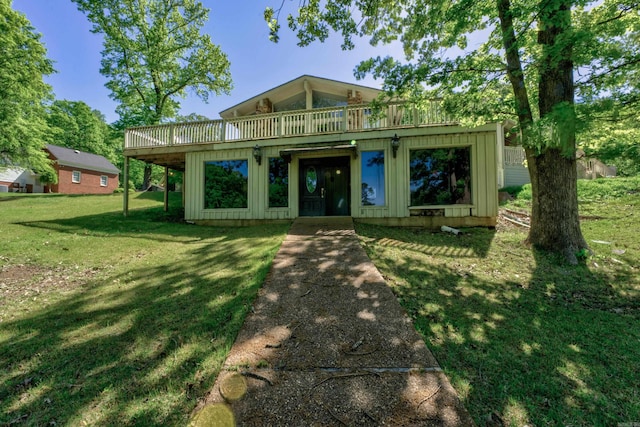 view of front of house featuring a front lawn and a balcony