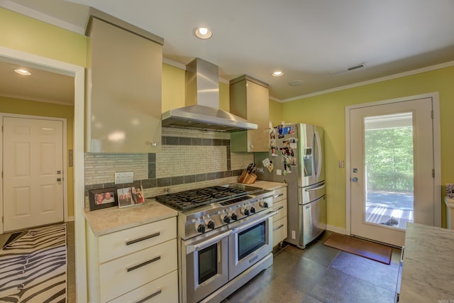 kitchen with crown molding, backsplash, appliances with stainless steel finishes, wall chimney range hood, and dark tile flooring