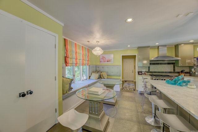 dining area featuring a notable chandelier, tile floors, and ornamental molding