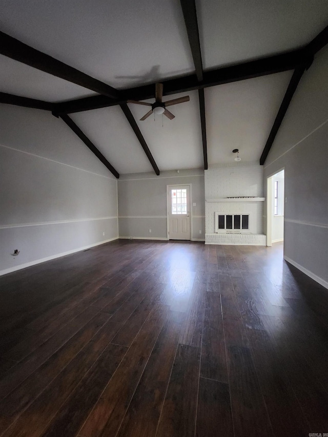 unfurnished living room featuring ceiling fan, dark wood-type flooring, vaulted ceiling with beams, and a brick fireplace