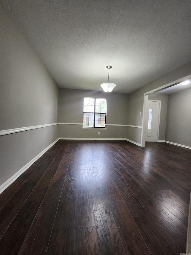 unfurnished room featuring a textured ceiling and dark wood-type flooring