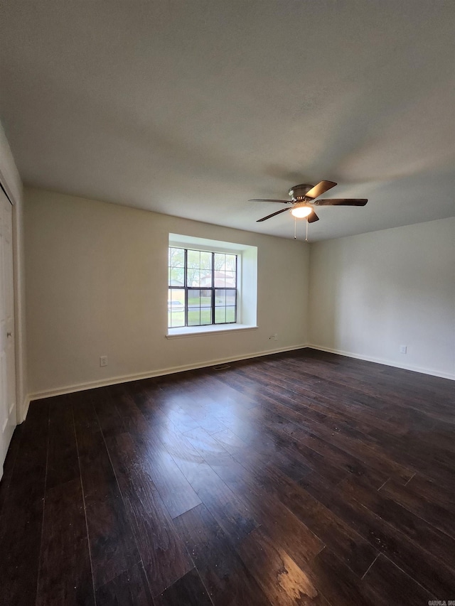 unfurnished room with ceiling fan and dark wood-type flooring