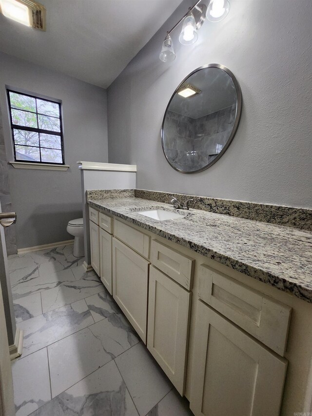 bathroom with vanity, toilet, and tile flooring