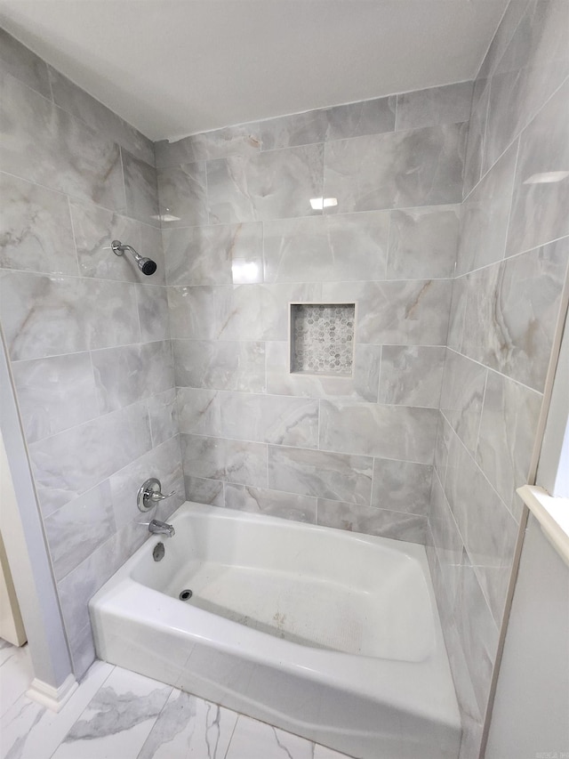 bathroom featuring tiled shower / bath combo and tile floors