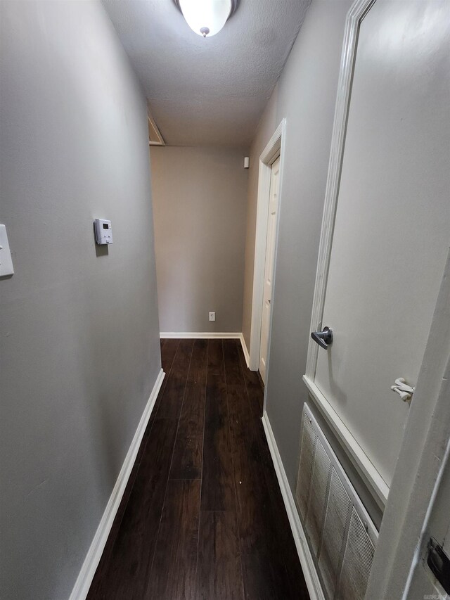 hallway featuring wood-type flooring and a textured ceiling