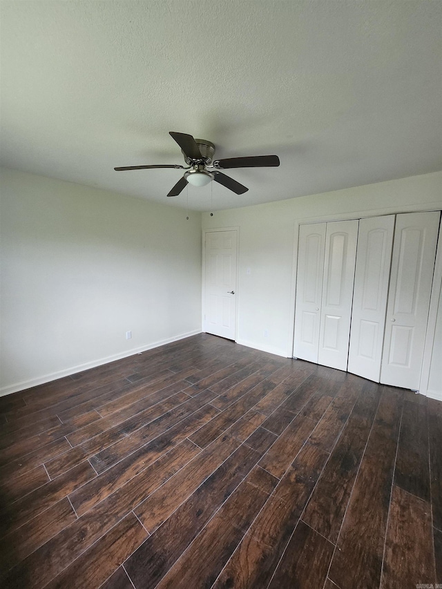 unfurnished bedroom with dark hardwood / wood-style flooring, ceiling fan, and a textured ceiling