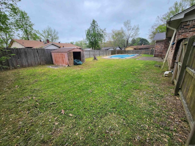 view of yard with a storage shed and a fenced in pool