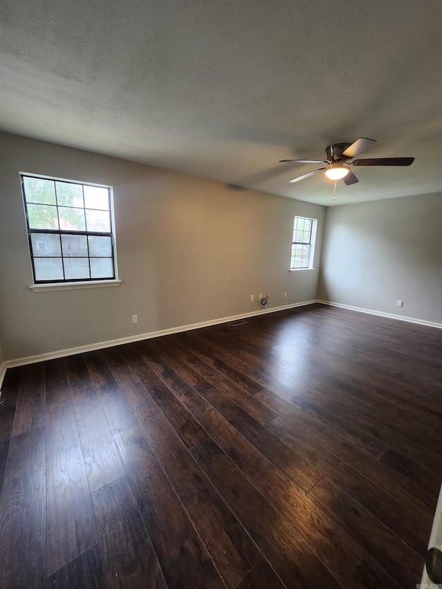 spare room featuring ceiling fan, dark hardwood / wood-style floors, and a textured ceiling