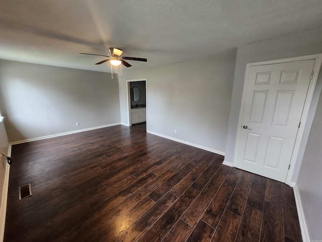 spare room featuring a textured ceiling, ceiling fan, and dark wood-type flooring