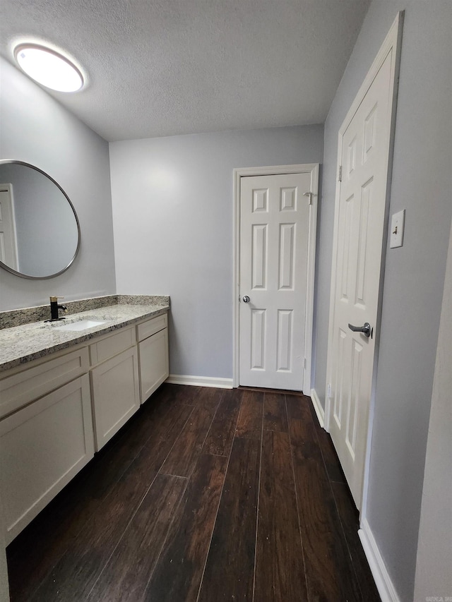 bathroom featuring a textured ceiling, hardwood / wood-style floors, and vanity