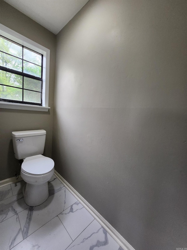 bathroom featuring toilet and tile floors