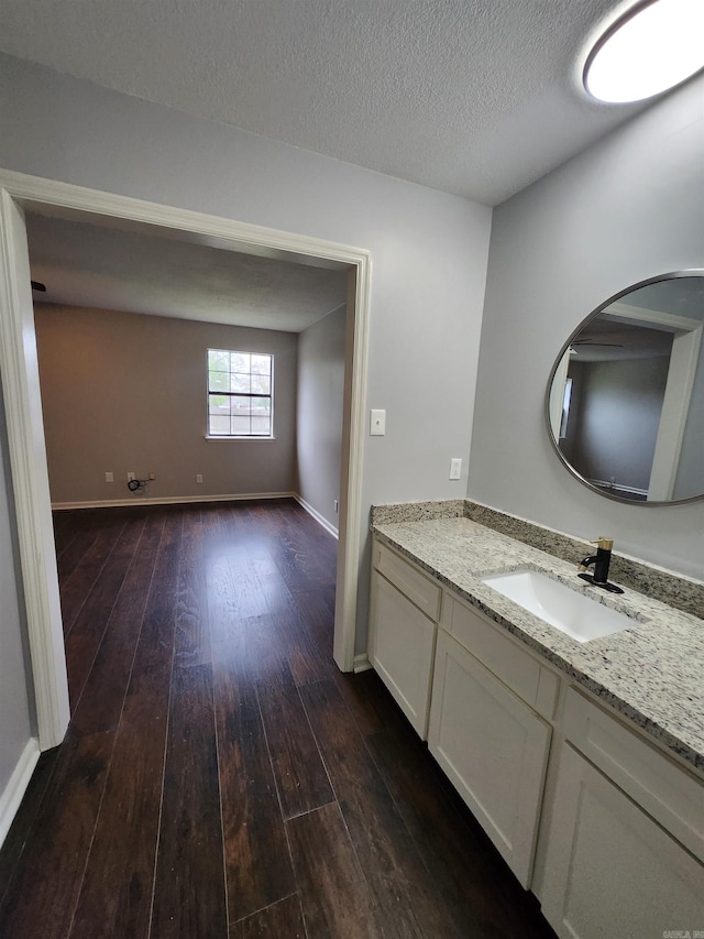 bathroom featuring vanity with extensive cabinet space, a textured ceiling, and hardwood / wood-style floors