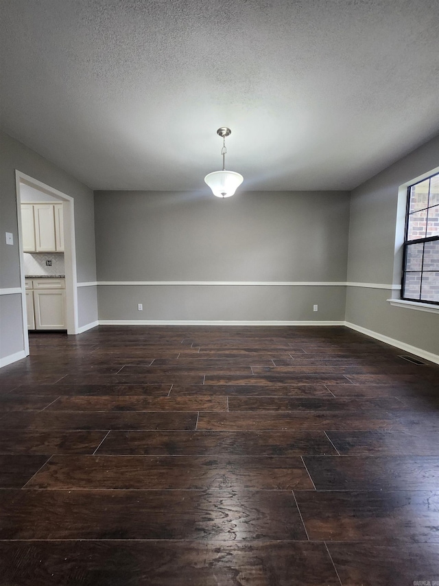 unfurnished room featuring dark hardwood / wood-style floors and a textured ceiling