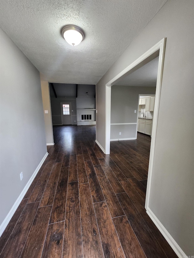 corridor with dark hardwood / wood-style floors and a textured ceiling