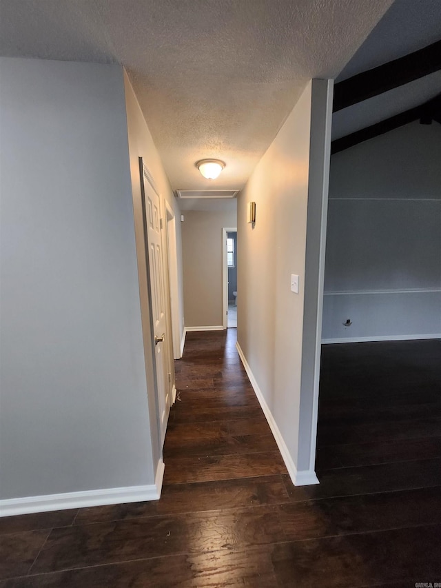 hallway with dark hardwood / wood-style flooring and a textured ceiling